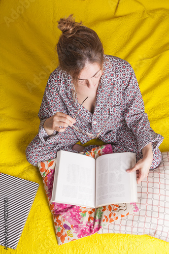 woman reading in pajamas on the bed