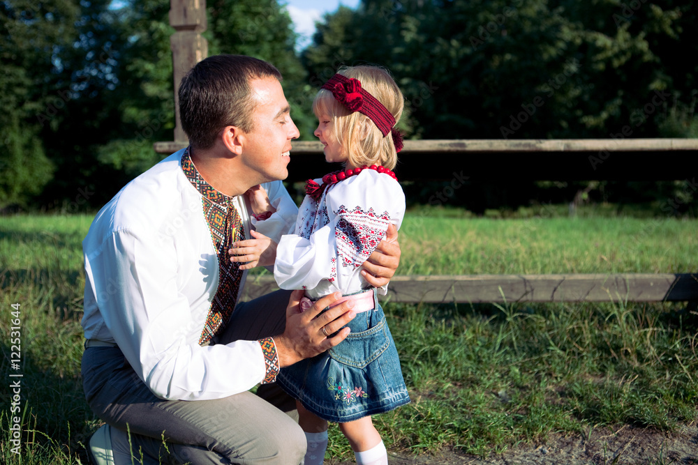 Fototapeta premium Sunshine illuminates happy father hugging his little daughter