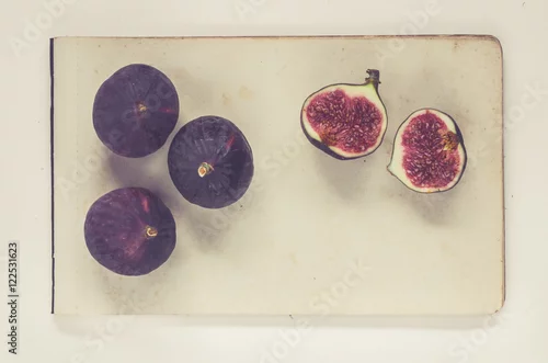 Obraz figi leżące na kartkach papieru w stylu vintage - książka w stylu historii naturalnej