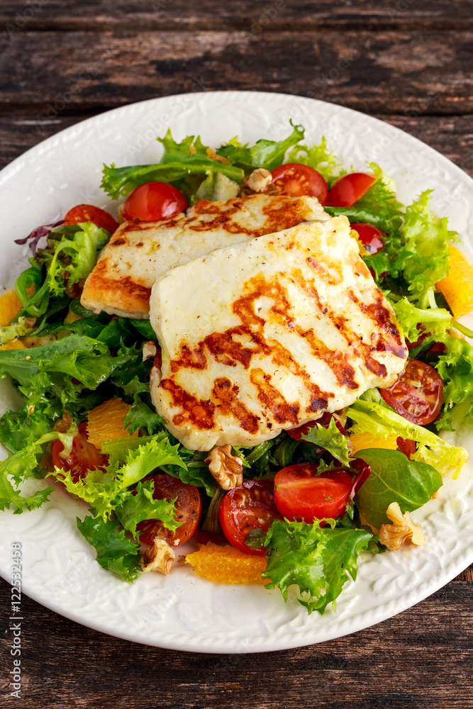 Grilled Halloumi Cheese salad witch orange, tomatoes and lettuce. healthy food
