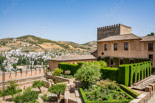 View of the Nasrid Palaces (Palacios Nazaríes) and gardens in front of them in Alhambra, Granada on a beautiful day, Spain 
