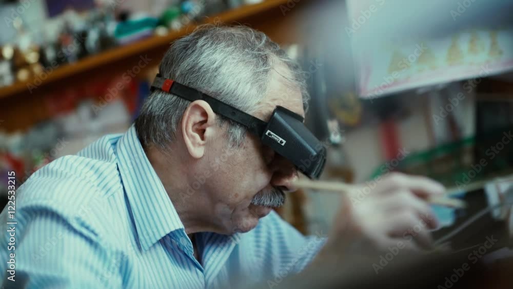 Architect wears magnifying glasses. Drawing. The work of the architect. A man with a mustache draws special glasses for architects. Magnifying glasses for smaller jobs. Architect draws