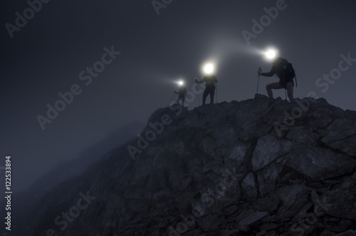 Lightbeams in the darkness on mountain ridge © Chris