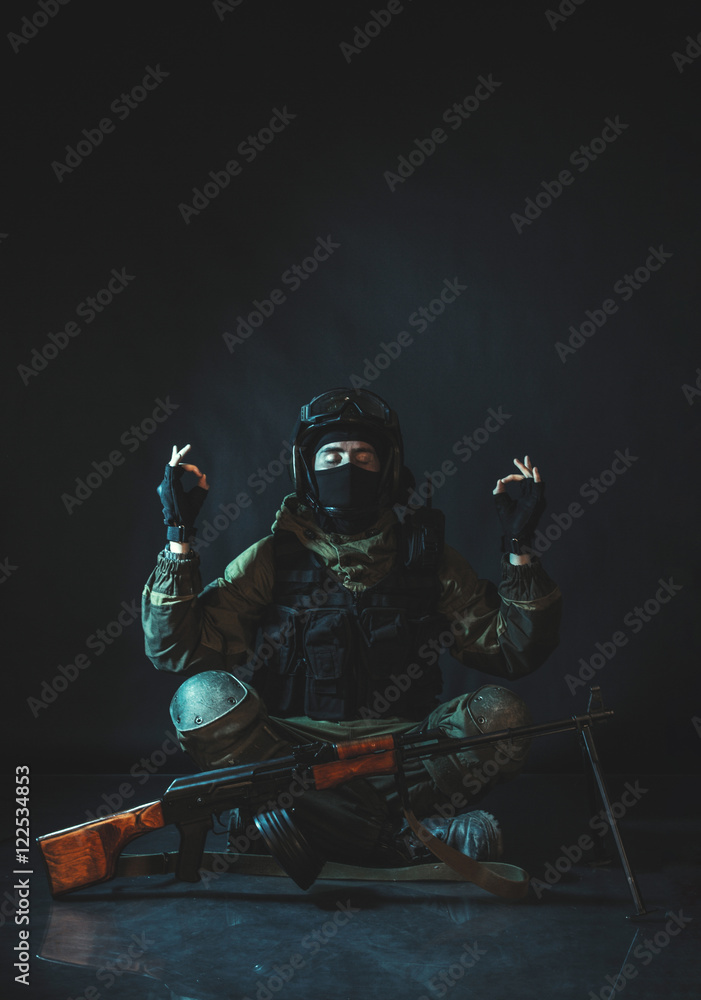 Young fitness member of special forces division meditation in dark room. Man is practicing yoga.Soldier knowing peace and harmony. Russian police special force - Special Rapid Response Unit (Spetsnaz) Young fitness member of special forces division meditation in dark room. Man is practicing yoga.Soldier knowing peace and harmony. Russian police special force - Special Rapid Response Unit (Spetsnaz)