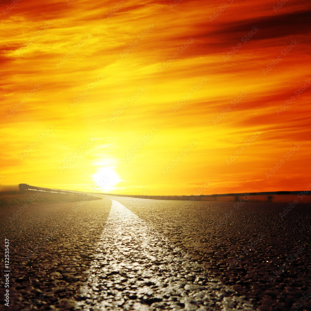 red sunset and asphalt road closeup