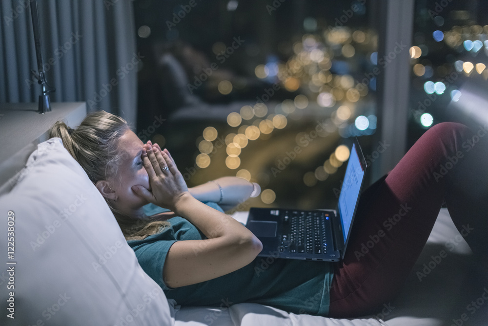 Young exhausted,depressed,concentrated woman lying in bed in bedroom