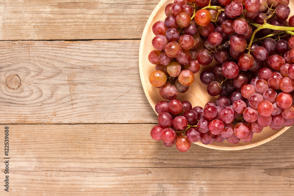 Red grapes on old wooden table Red grapes on old wooden table