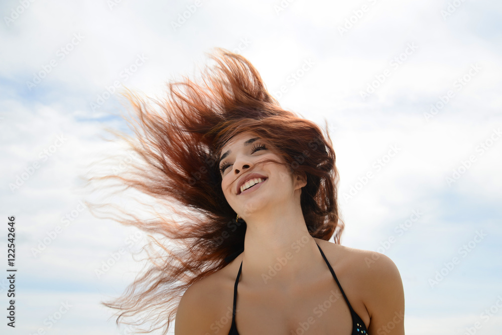 Naklejka premium happy beautiful young woman shaking hair