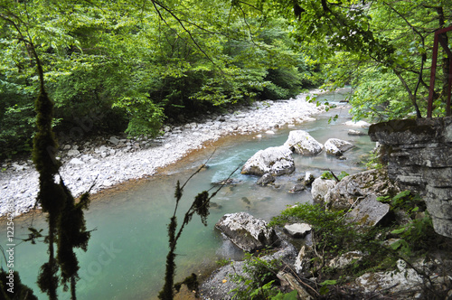 Fast mountain river with rocky shore photo