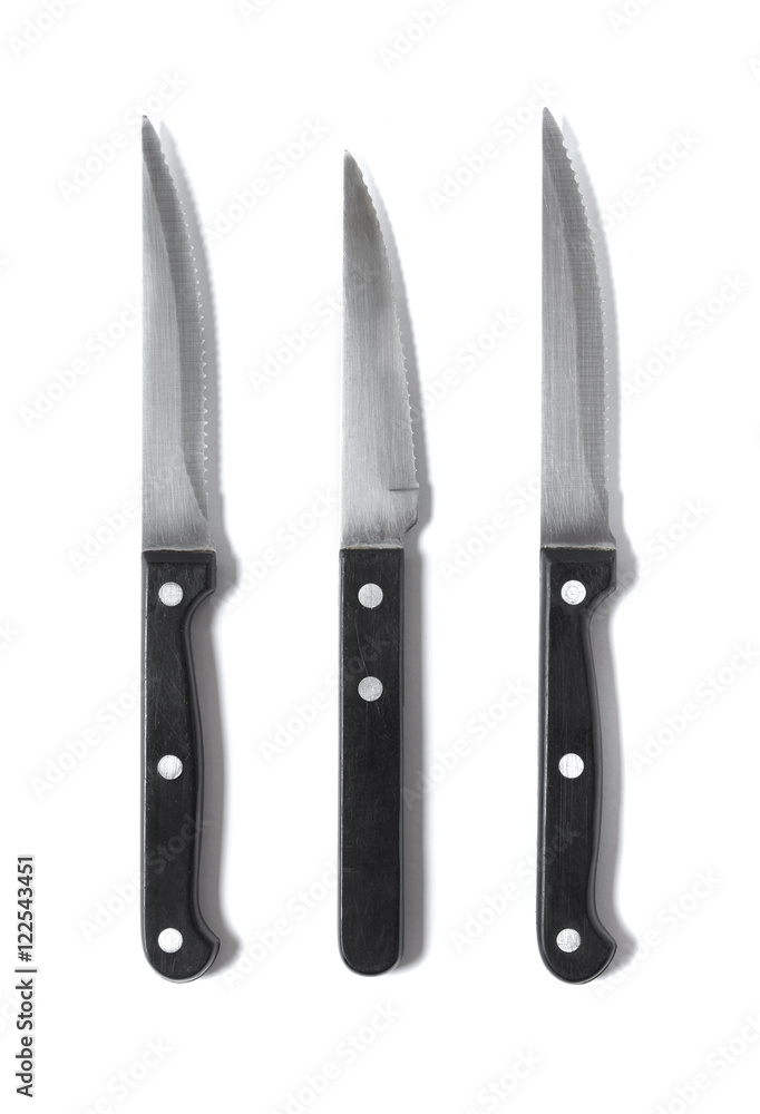 Assorted black and silver steak knives isolated on a white background Assorted black and silver steak knives isolated on a white background