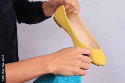 Leather shoes care. Female cleaning flat shoes close up