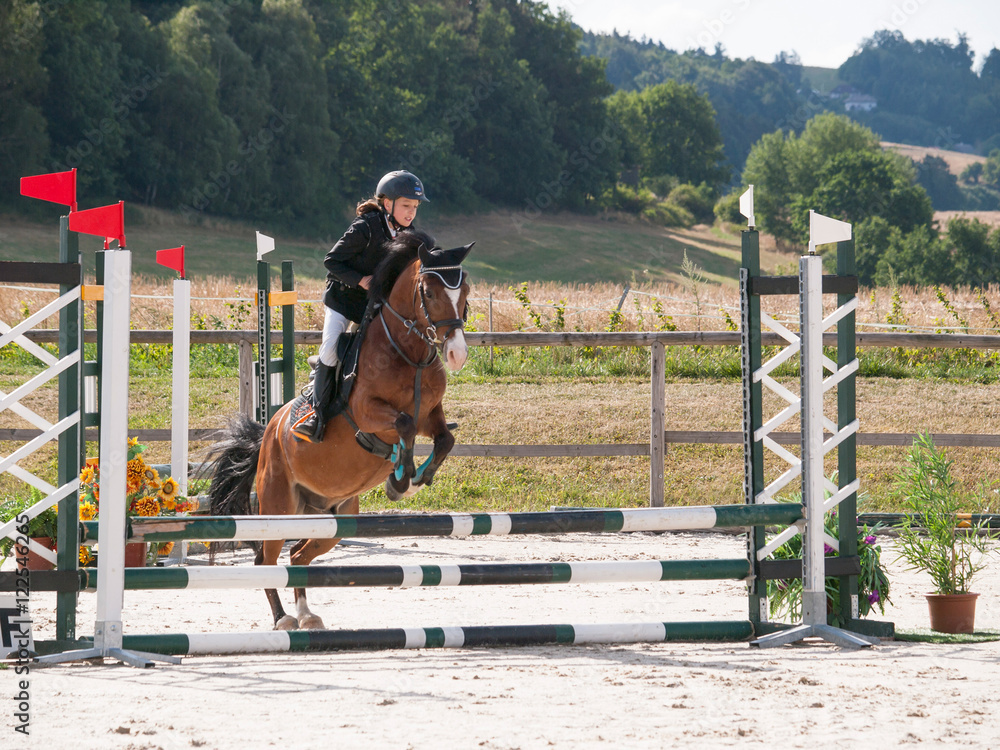 Portrait of girl riding pony on showjumping competition