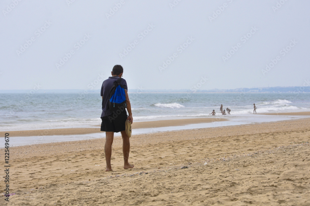 Adult man taking a stroll on the beach in Huelva, Spain
