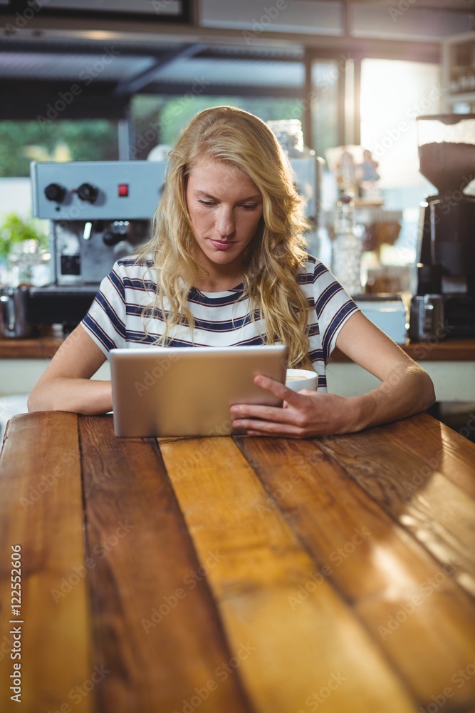 Woman sitting in a cafe using digital tablet Woman sitting in a cafe using digital tablet