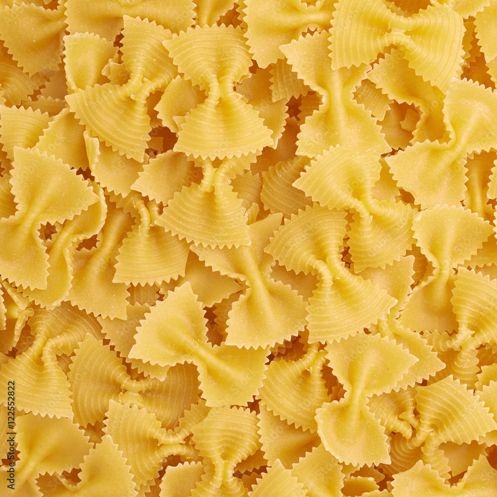 Pile of farfalle yellow pasta as abstract background Pile of farfalle yellow pasta as abstract background
