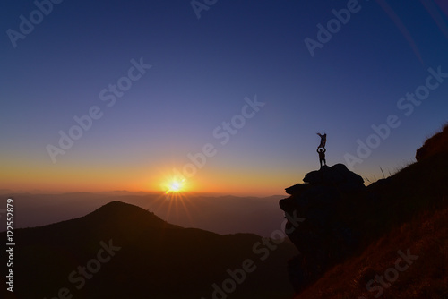 man standing on the rock on top of the mountain success concept.