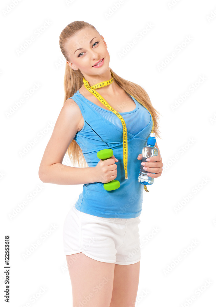 Young woman doing fitness exercise, isolated on white background. Portrait of beautiful athlete girl with bottle of water, dumbbells and tape measure in studio. Young woman doing fitness exercise, isolated on white background. Portrait of beautiful athlete girl with bottle of water, dumbbells and tape measure in studio.