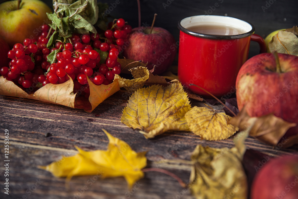 Hot tea cup on an autumn day. Table background with leaves and a