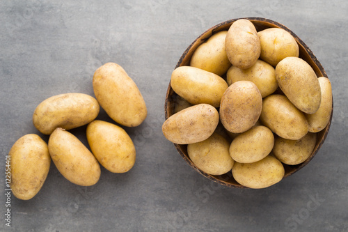 New potato on the bowl, gray background.