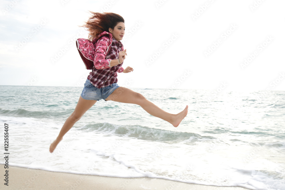 beautiful girl with colorful windbreaker running on the beach beautiful girl with colorful windbreaker running on the beach