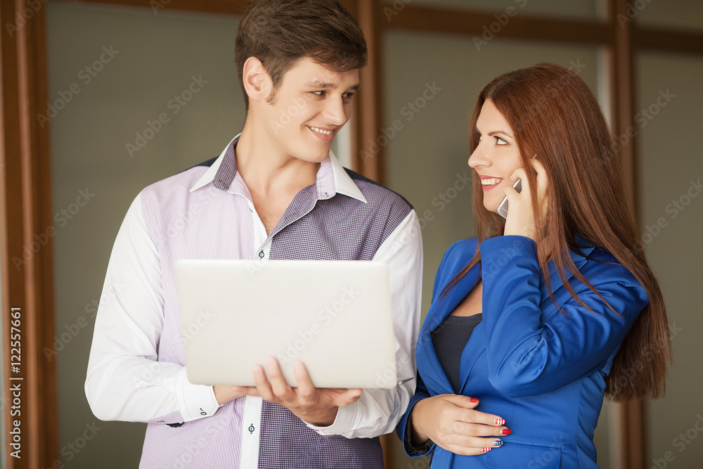 Portrait of two professionals looking at a laptop screen Portrait of two professionals looking at a laptop screen
