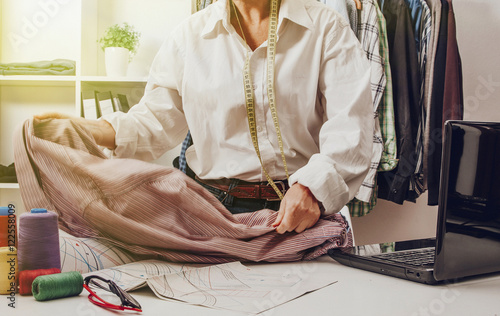 Foto dressmaker working in the sewing workshop