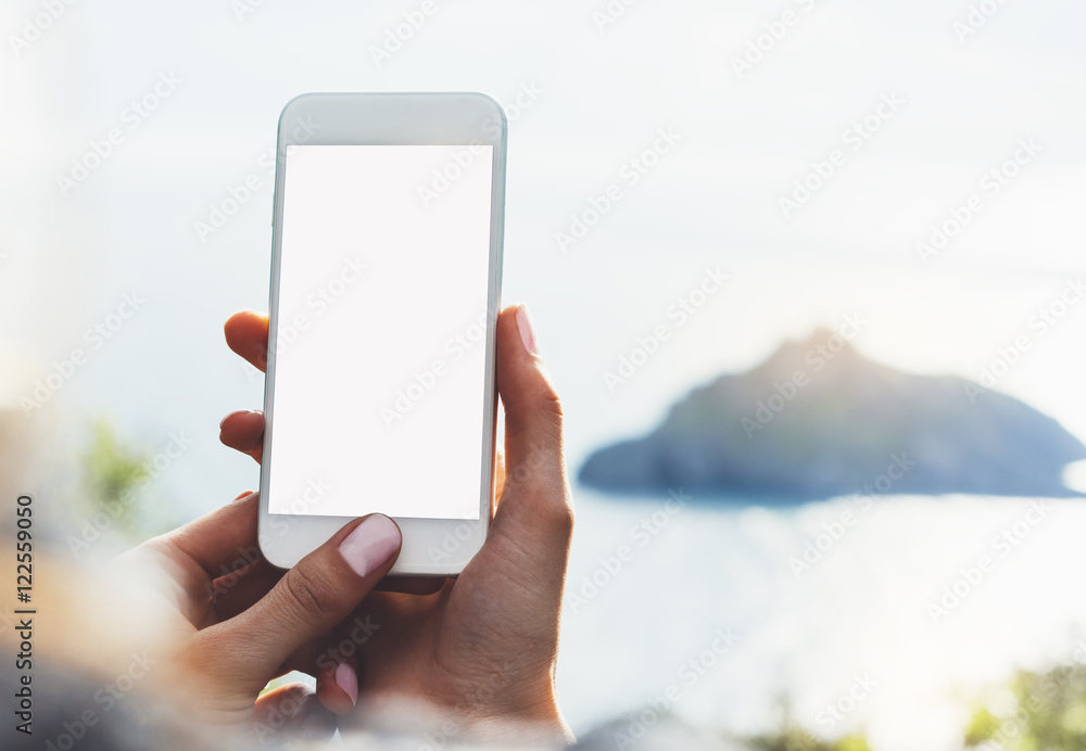 Hipster girl texting message on blank mobile close up, view tourist hands using gadget phone on device travel on background green mountains landscape; finger touch screen cellphone mockup nature