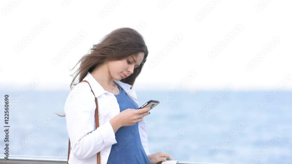 Woman walking near the sea with smartphone, waiting somebody Woman walking near the sea with smartphone, waiting somebody
