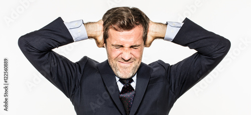 Valokuva annoyed young business man covering his ears from corporate burnout