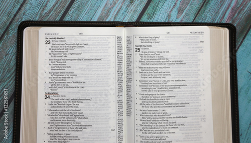 Bild auf Leinwand An Opened Bible on a Turquoise Distressed Wooden Table