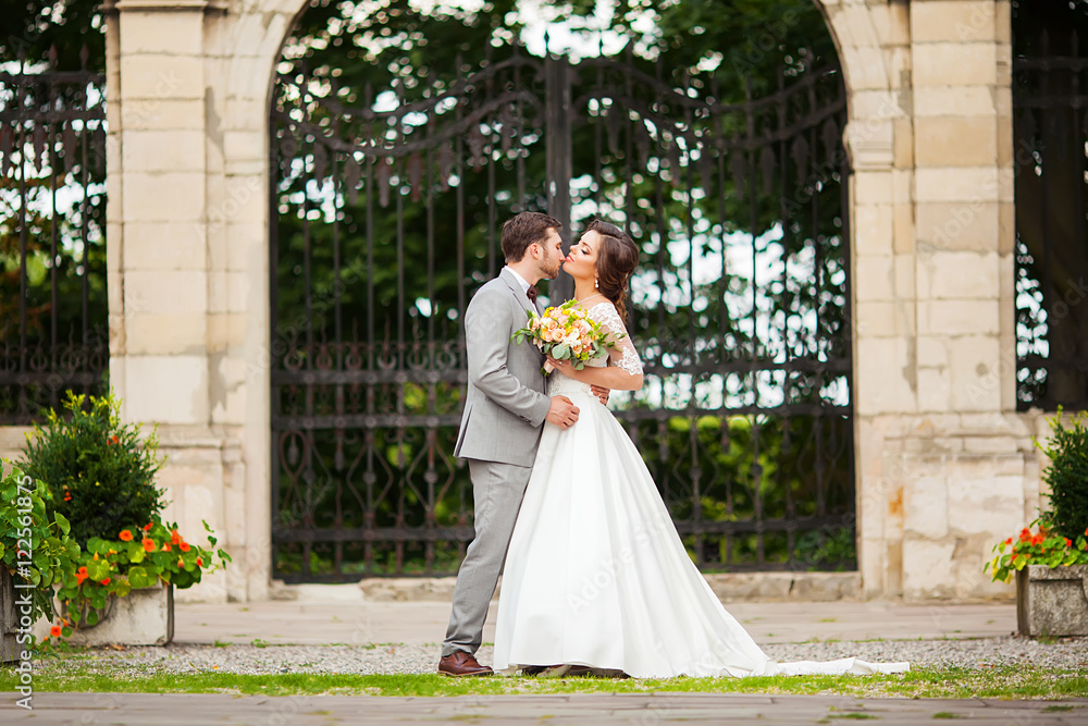 Bride and groom in a park kissing.couple newlyweds bride and groom at a wedding in nature green forest are kissing photo portrait.Wedding Couple Bride and groom in a park kissing.couple newlyweds bride and groom at a wedding in nature green forest are kissing photo portrait.Wedding Couple