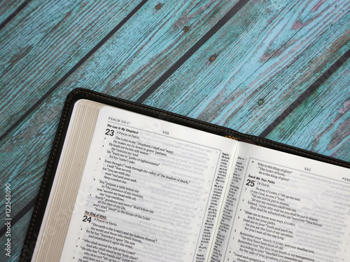 An Opened Bible on a Turquoise Distressed Wooden Table