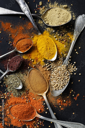 Various spices and herbs on black background , top view