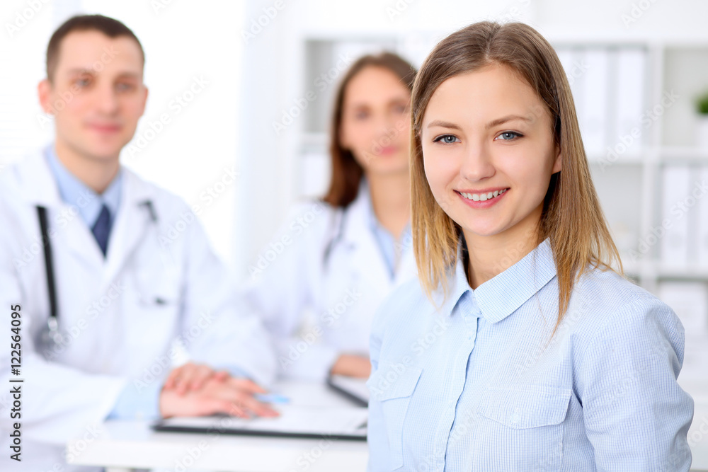 Friendly male doctor on the background with patient in hospital. High level and quality medical service concept. Friendly male doctor on the background with patient in hospital. High level and quality medical service concept.
