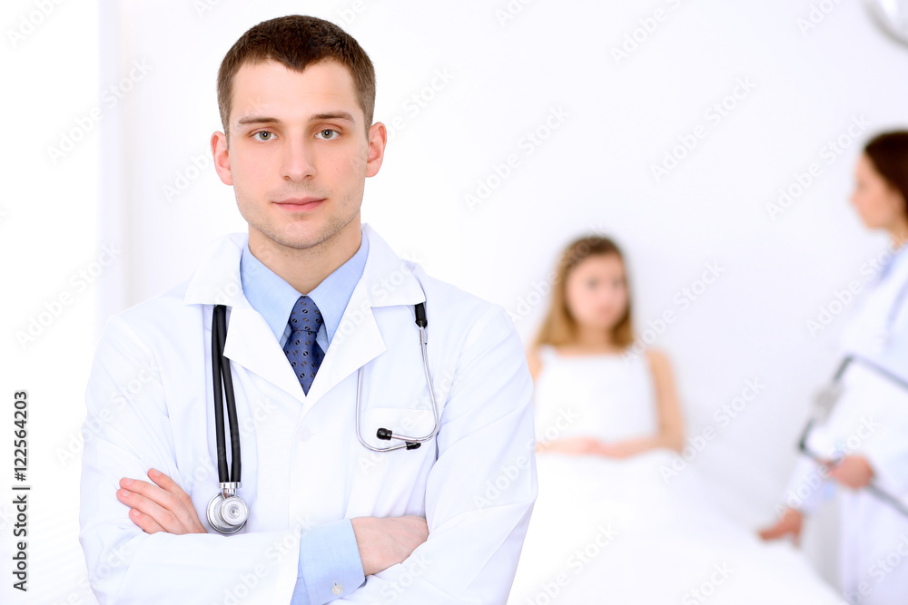 Friendly male doctor on the background with patient in the bed Friendly male doctor on the background with patient in the bed