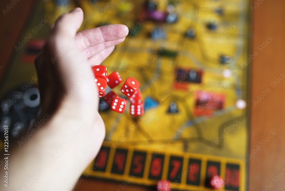 Several rolling red dice fall on a table with boardgame. Gameplay moments Several rolling red dice fall on a table with boardgame. Gameplay moments