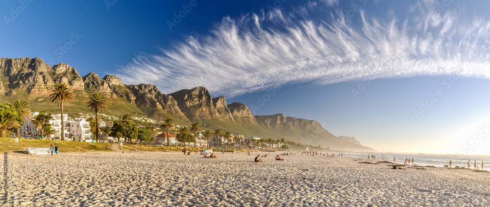 Fototapeta premium Oszałamiająca panorama XXL Camps Bay, zamożnych przedmieść Kapsztadu, Western Cape w RPA. Dzięki swojej białej plaży Camps Bay przyciąga wielu zagranicznych gości, a także mieszkańców RPA.