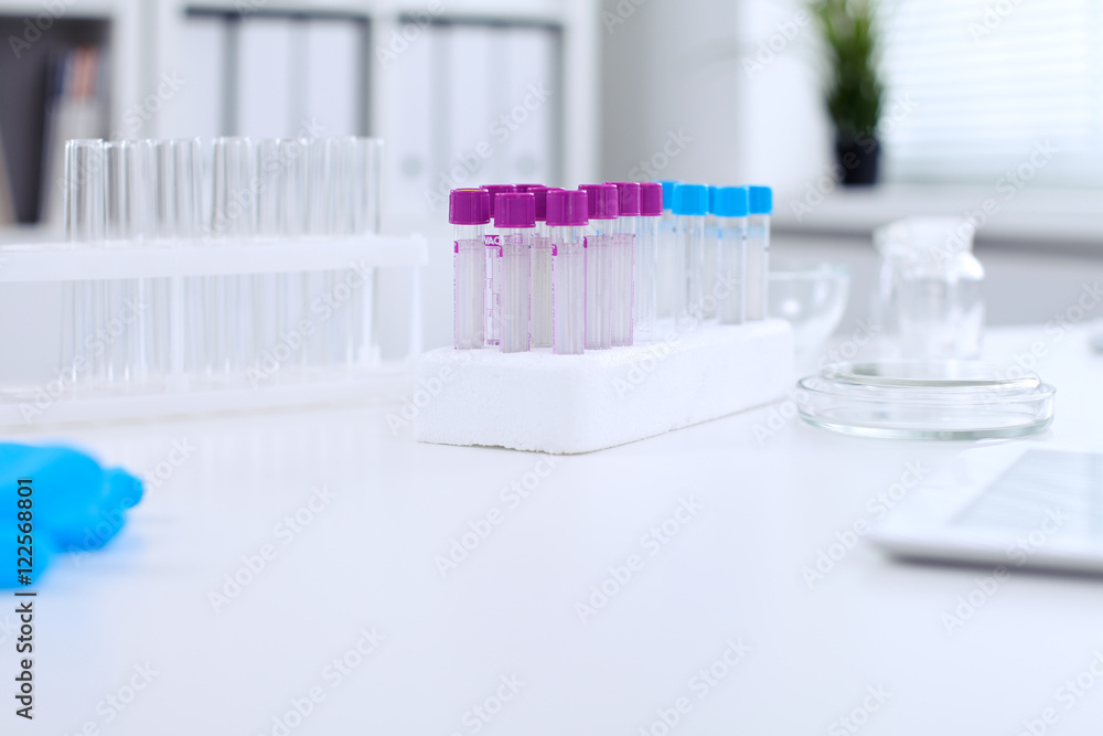 Research laboratory working space. Test tubes and tablet PC are lying at the table. Medical equipment. Blood test Research laboratory working space. Test tubes and tablet PC are lying at the table. Medical equipment. Blood test