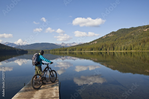 A male mountain biker enjoys a peaceful  moment in the morning before an all day ride in Spruce Lake Protected Area, Southern Chilcotins, British Columbia, Canada