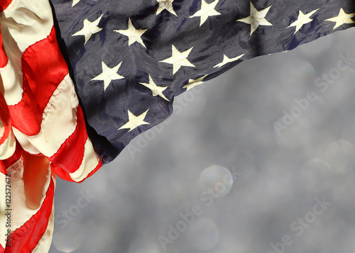 Rippled american flag corner curtain against blurred sparkling background with space for copy