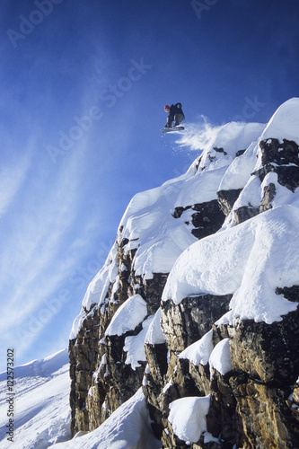 A young man getting huge air on his snowboard in the backcountry at Kicking Horse Resort, Golden, British Columbia, Canada. photo