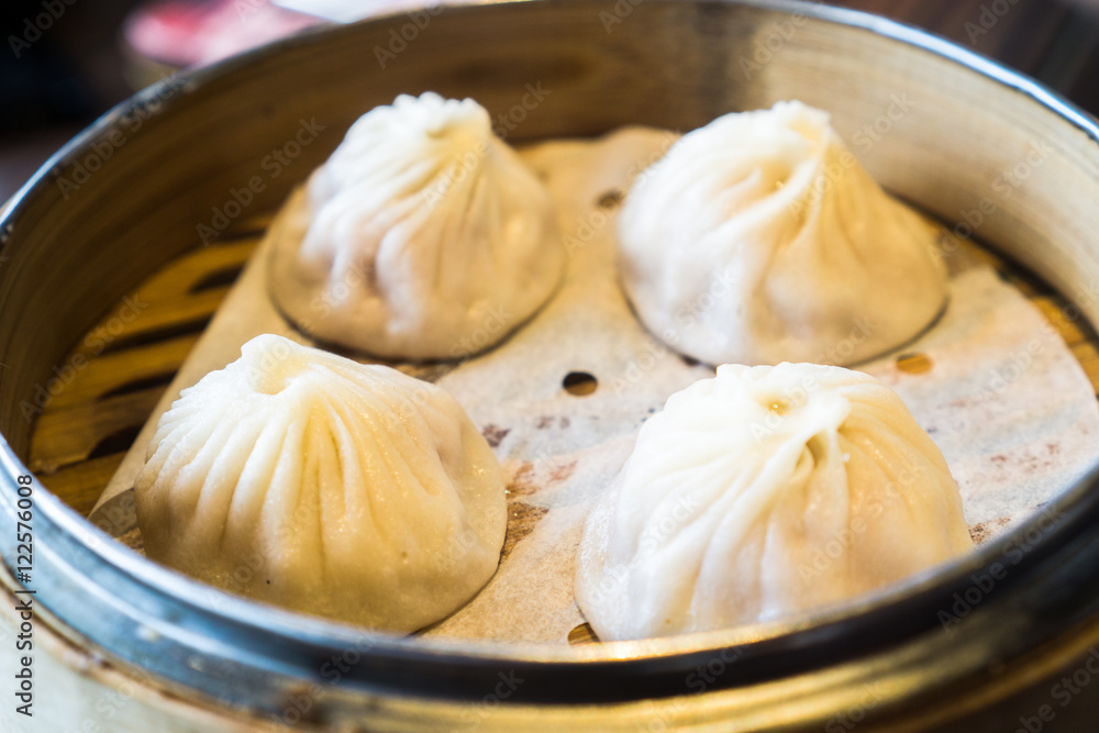 4 shrimp and pork Chinese dumplings know as Xaio Long Bao in hot bamboo tray 4 shrimp and pork Chinese dumplings know as Xaio Long Bao in hot bamboo tray