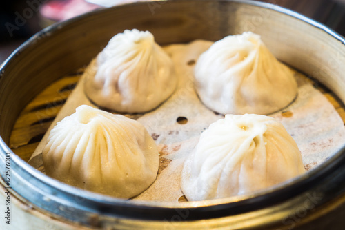Photography 4 shrimp and pork Chinese dumplings know as Xaio Long Bao in hot bamboo tray