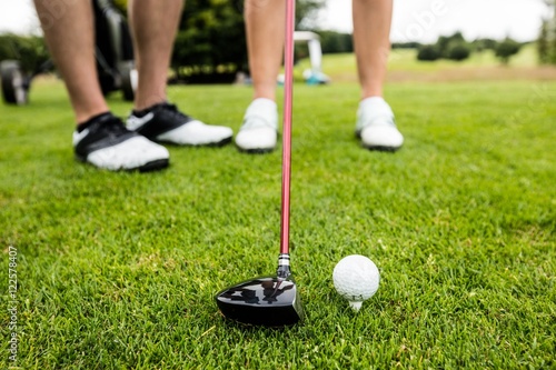 Męski instruktor pomaga kobiety w uczenie się golfa