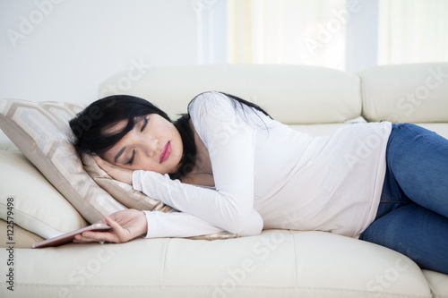 Woman with cellphone sleeps on sofa