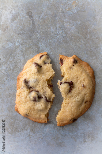 Schilderij op canvas 2 halves of chocolate chip cookie on a gray baking sheet
