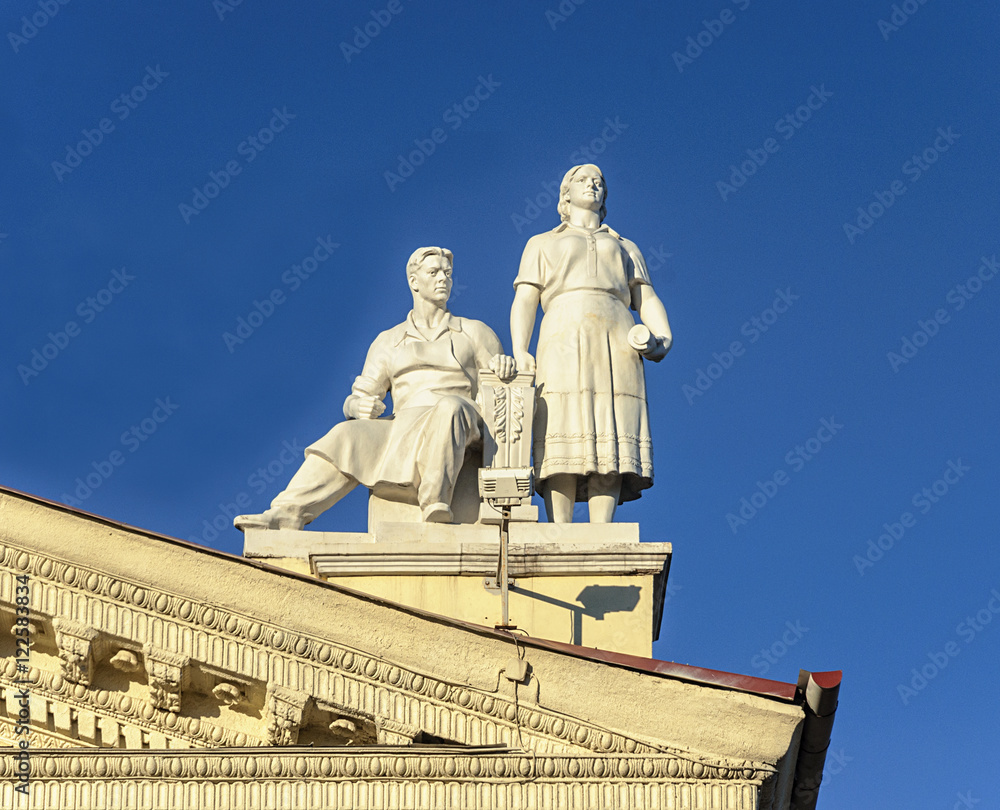 Obraz premium Sculpture of man and women on the roof of Trade Union Palace in
