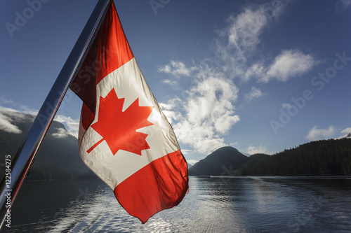 The Canadian Flag flies from the stern of the Uchuck 111 as it traverses Muchalat Inlet, British Columbia, Canada. photo