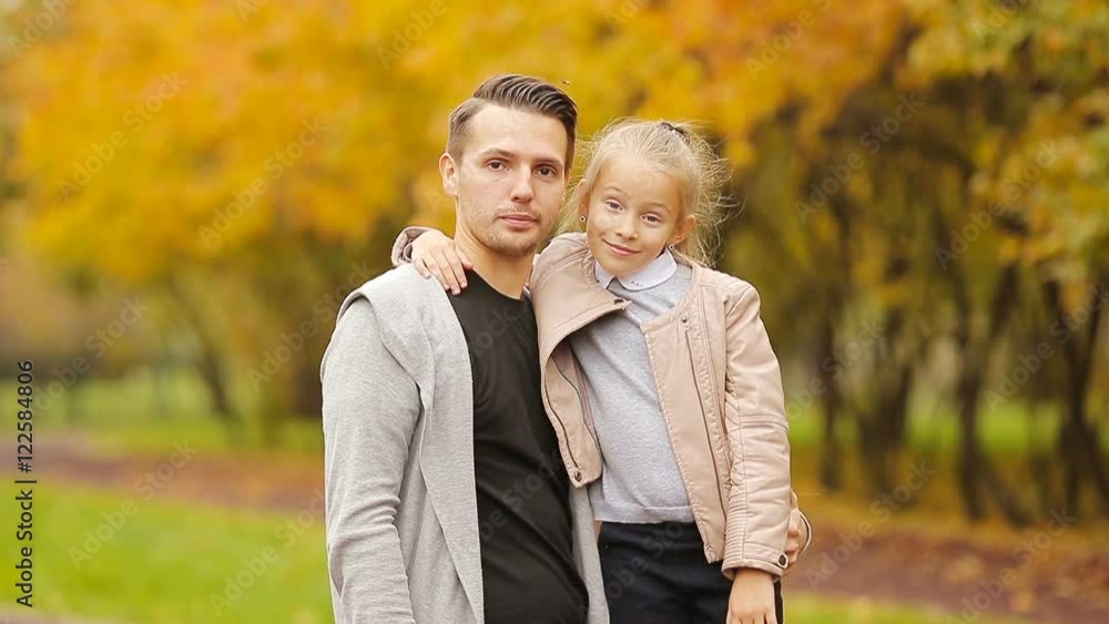 Portrait of little girl and happy father enjoy fall day in autumn park outdoors. Autumn family vacation Portrait of little girl and happy father enjoy fall day in autumn park outdoors. Autumn family vacation
