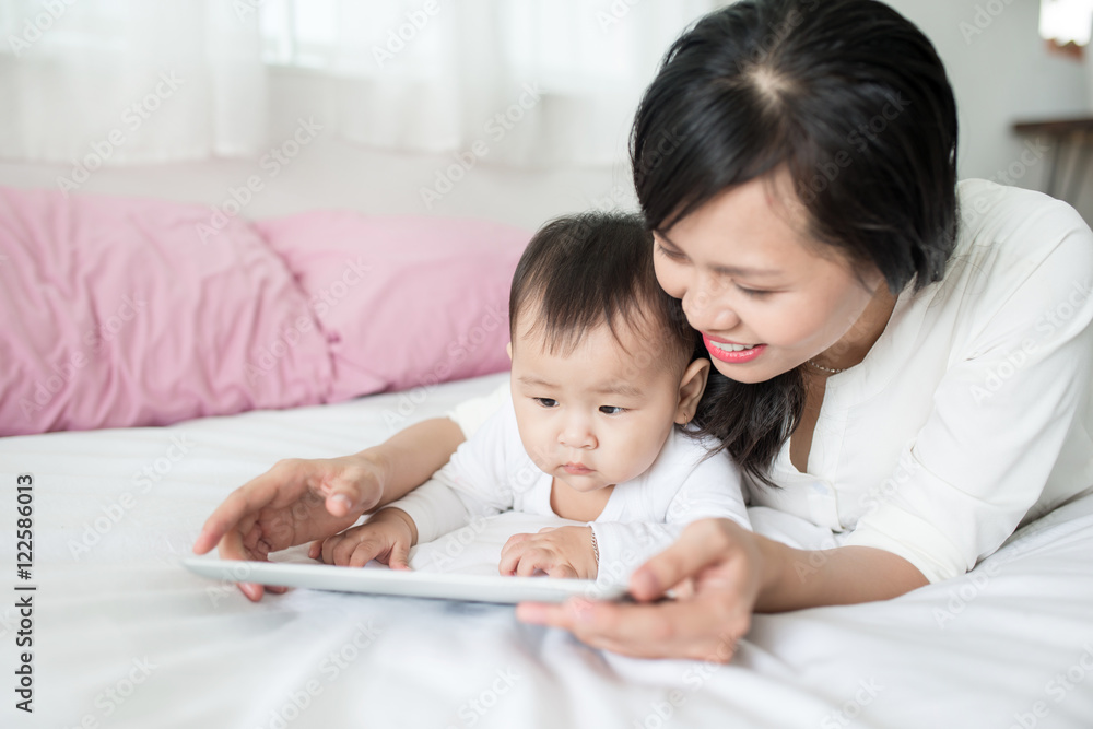Mother and baby are looking to play and read tablet computer at Mother and baby are looking to play and read tablet computer at